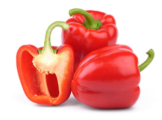 Whole and halved red sweet peppers isolated on white background.