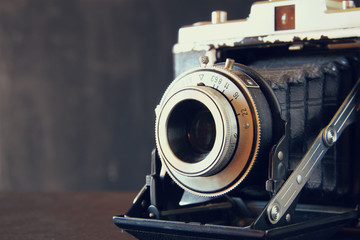 close up photo of old vintage camera lens over wooden table. selective focus
