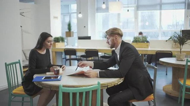 Business Partners at the meeting. Lady discusses strategy with a man.