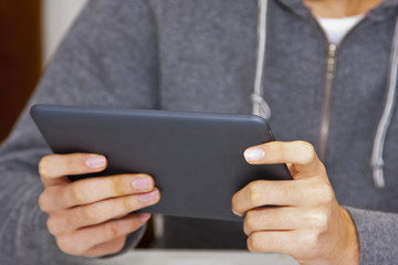 young teenage boy with the tablet in the foreground