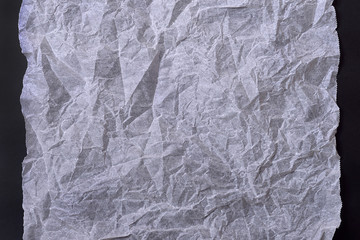 White crumpled paper on black background