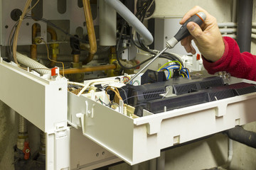 Elettricista che ripara una caldaia a condensazione