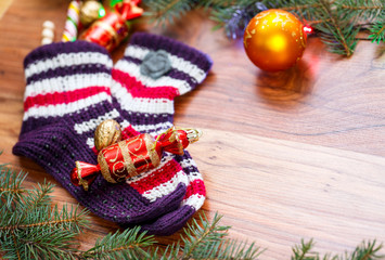 Composition of celebration with socks, fir branches and sweets, wooden Christmas background with space for text, card for the winter holidays, xmas, Christmas and New Year
