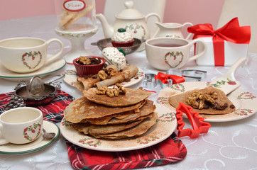 Bunch of delicious pancakes on Christmas crockery