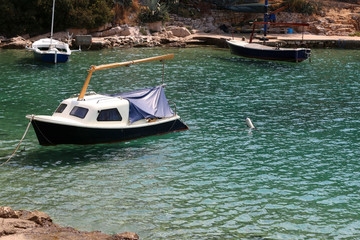 Fototapeta na wymiar Small boats in clear blue sea. In town Vela Luka, on the Korcula island, Croatia.