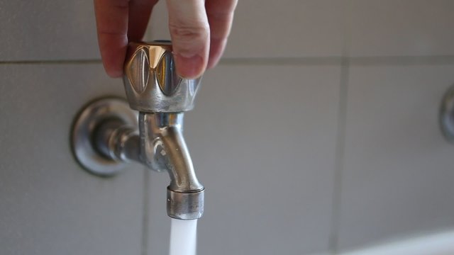 hand of a boy opening the tap