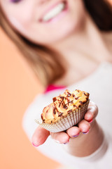 Delicious sweet cupcake in human hand. Gluttony