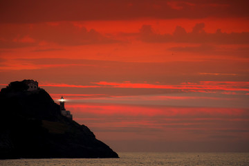 Beaming lighthouse in the red dusk 