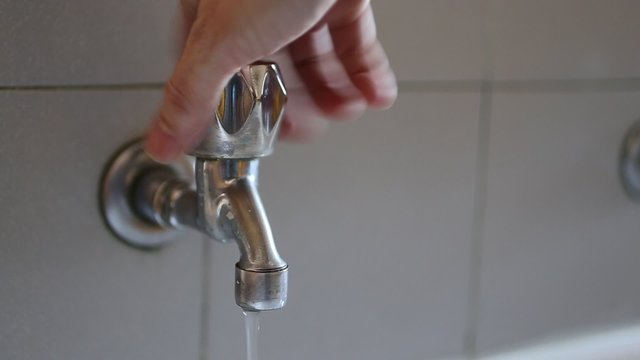 hand of a young man who closes the tap