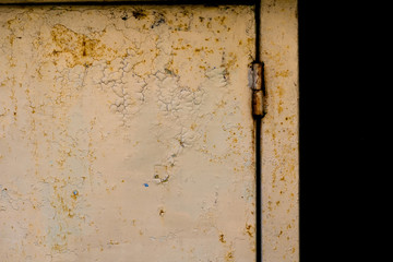 Rusty metal door and hinge on it.