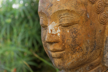 Fototapeta na wymiar buddhist statue in nature - garden decoration