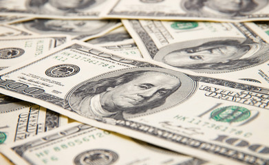 One hundred dollars pile as background.