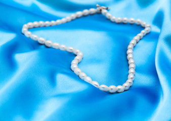 Pearls a necklace on a silk fabric
