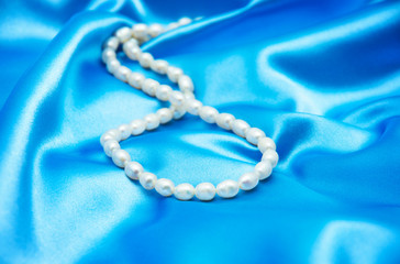 Pearls a necklace on a silk fabric
