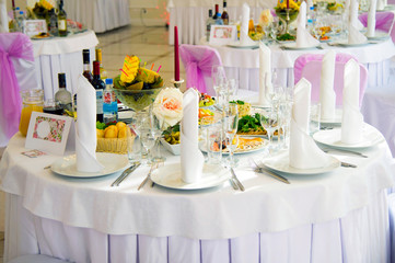 Festive table. Table setting. Festive round table with food.  Starched napkins and Cutlery. Festive meals. The restaurant inside. Service holidays. The design of the hall.