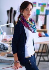 Beautiful fashion designer standing in studio