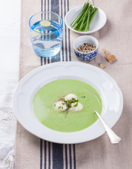 Green pea soup with spring onion and mozzarella on a table..