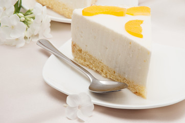 cheesecake with peaches on white plate