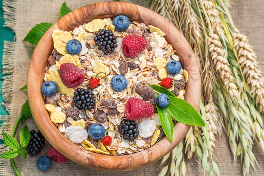 Tasty granola with berry fruits and milk in garden