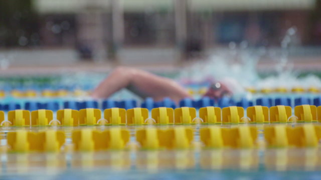 Side view of Swimmers in a Outdoor Olympic Pool in Extreme Slow Motion