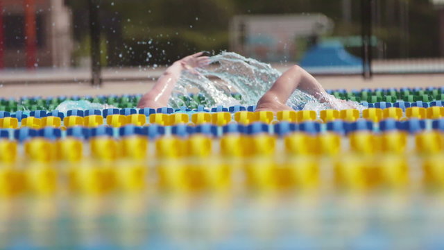 Side view of Swimmers in a Outdoor Olympic Pool in Extreme Slow Motion
