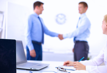 Business people shaking hands, finishing up a meeting, in office