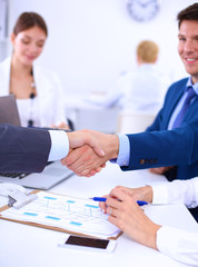 Fototapeta premium Business people shaking hands, finishing up a meeting, in office