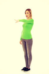 Shocked woman pointing aside.
