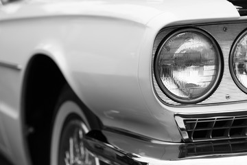 Close-up of left headlights of a white shiny classic vintage car