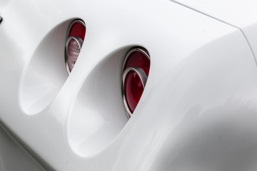 Close-up of red tail lights of a white shiny classic vintage car