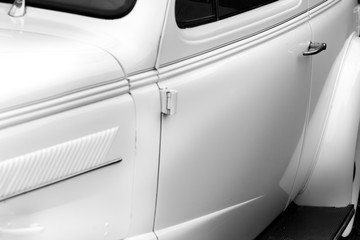 Close-up of car handle of a white shiny classic vintage car