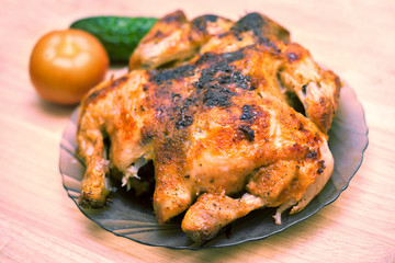 Delicious baked chicken on plate on table close-up