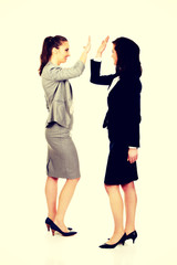 Two businesswomen giving a high five.