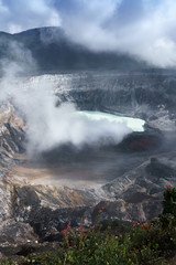 Fototapeta premium Steam erupting from active volcano with mountain range in background, Costa Rica