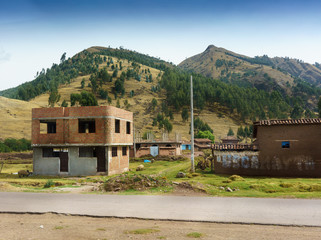 Fototapeta na wymiar Village on hill with mountain in background, Cusco, Peru