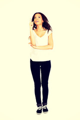 Fototapeta premium Young woman pointing up.