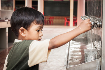  little asian boy press the drinking water