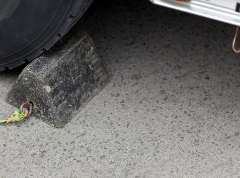 Close-up of chock beneath a car tyre