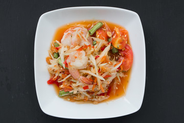Green papaya salad (Som Tum) with shrim on black background