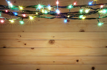 Christmas light boarder on wooden background.