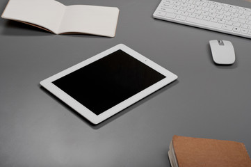 White tablet on a grey office desk