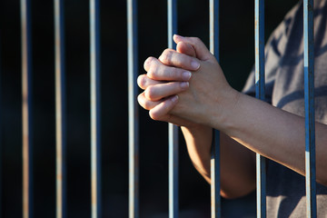 hand praying in jail