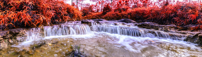 Panoramic view of Beautiful autumn waterfall in deep forest.