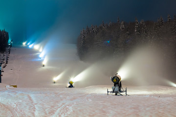 snow cannons working at night in the mountains