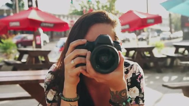 A beautiful girl taking pictures with a camera, slow motion