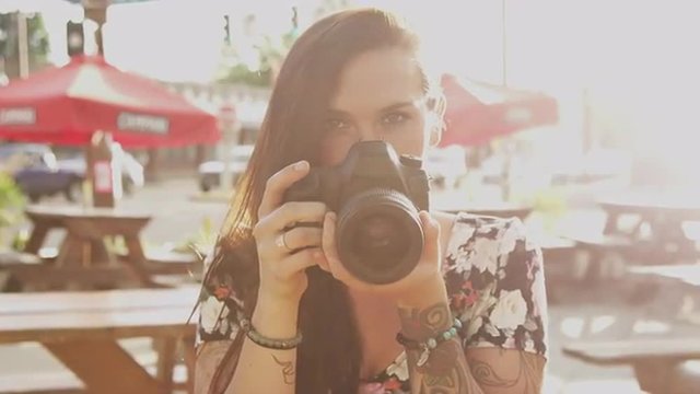 A beautiful girl taking pictures with a camera, slow motion