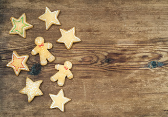 Christmas homemade gingerbread cookies of man and stars over rustic wooden background, top view