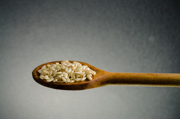 rice in a spoon, close up, color background.