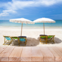 Wood table top on blurred blue sea and white sand beach backgrou