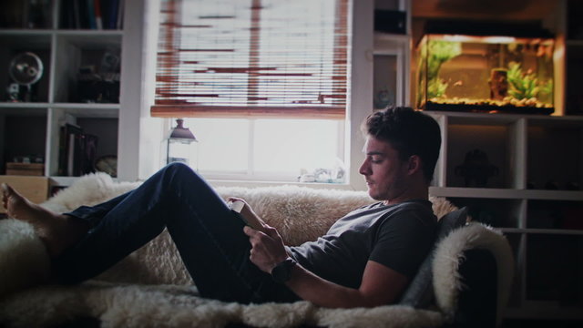 Cinemagraph (Photo-Motion) of a Young Relax Adult Reading a Book on the Couch